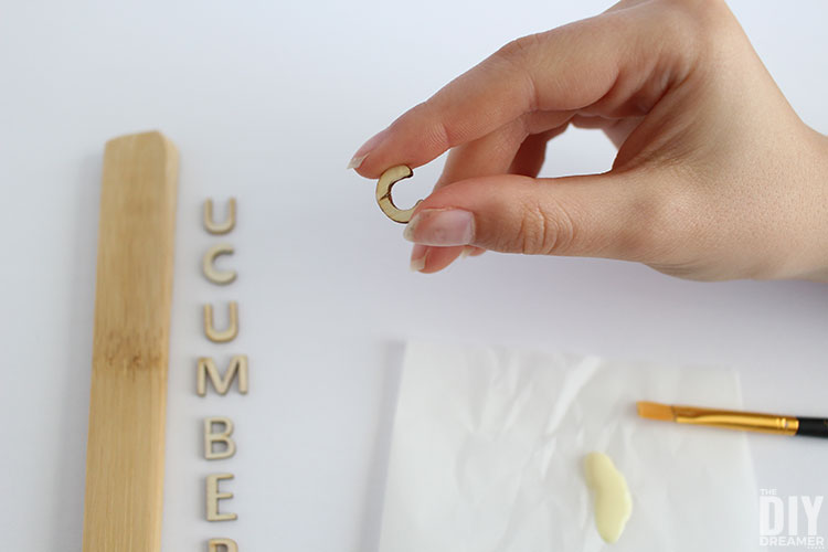 Mini wood letter with glue on the back.