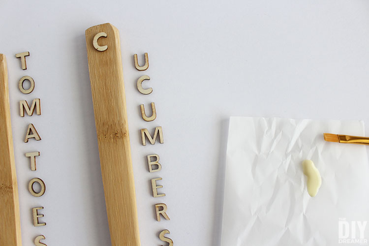 Letter C glued on the handle of a spoon with the remaining letters spelling cucumbers.