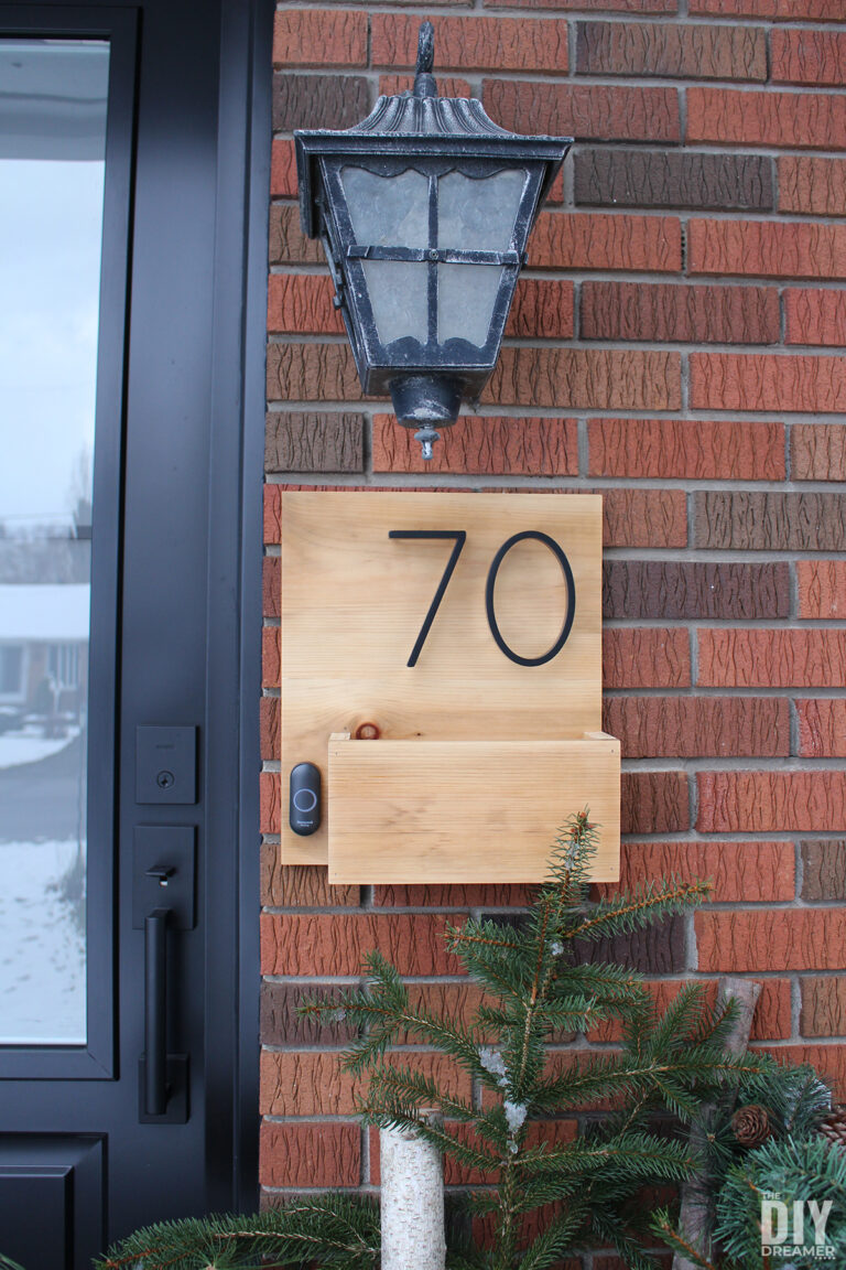 House number sign with doorbell and box